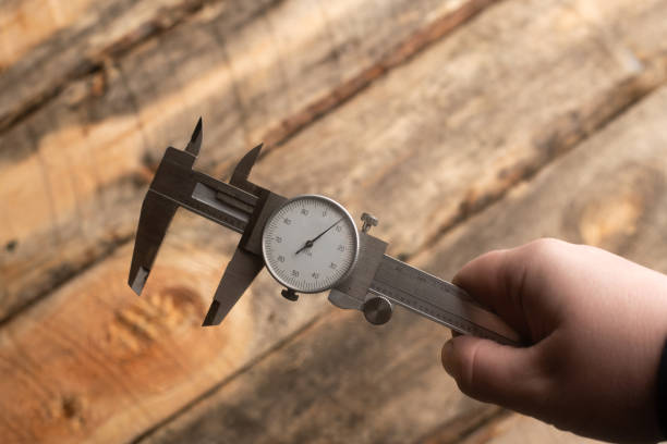 A close-up of a vernier caliper measuring the diameter of a metal rod, with the main scale and vernier scale clearly visible."